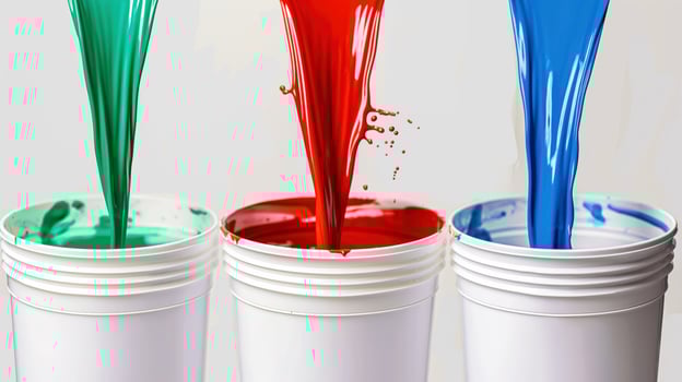 Bold colors of paint pour out, filling up the containers below photo