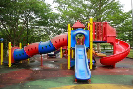 An outdoor children's play area with lush trees photo
