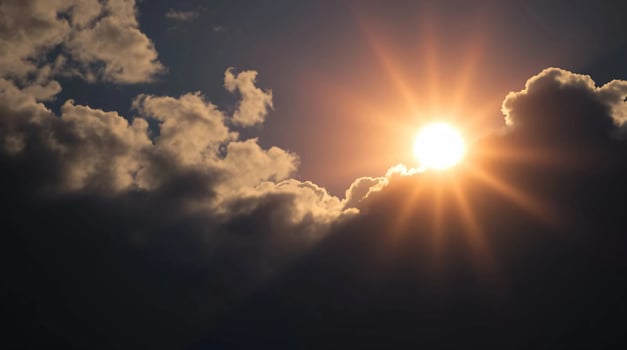 The sun is shining through the clouds in this photo