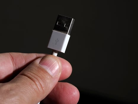 hand holding usb plug close up photo