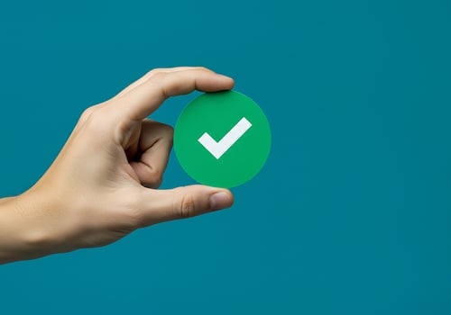 A person holding a green check mark on a blue background photo