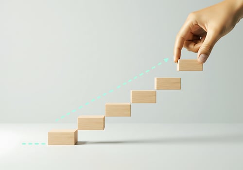 Hand reaching up to a wooden block with arrows photo