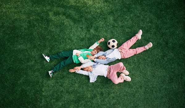 Top view. Lying down. Kids are having fun on the green soccer field together photo