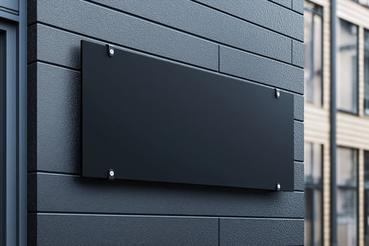 A black sign is on a wall photo