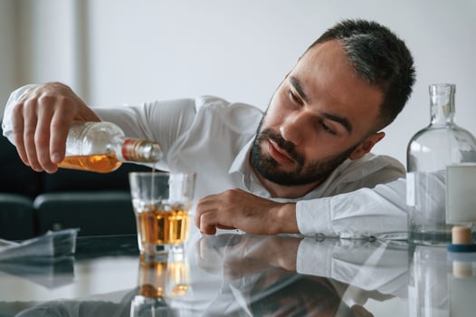 Conception of addiction. Upset, young man drinker alcoholic is indoors photo