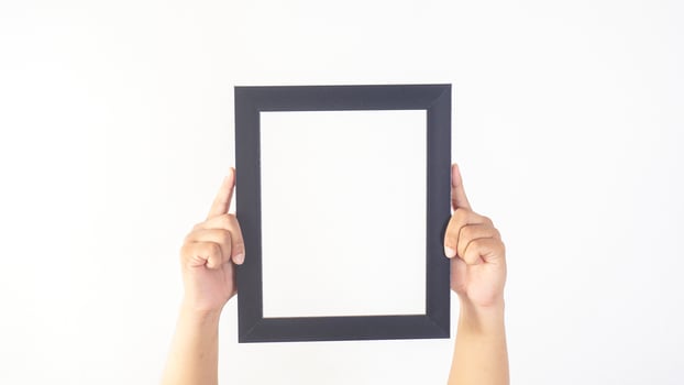 Hand holding black colored wood photo frame isolated on white background