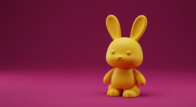 A small yellow bunny toy on a purple background photo