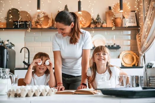 On the ,kitchen ,with garlands together. Mother with her little two daughters is preparing food photo