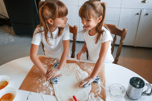 Two little girls are preparing food on the kitchen photo
