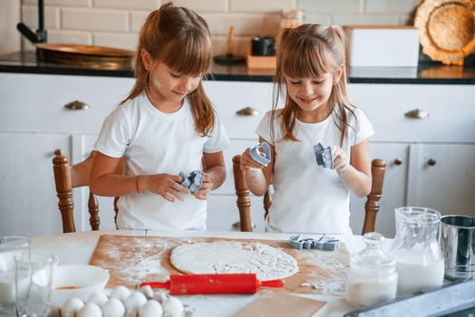 Two little, girls are preparing food on the kitchen with garlands photo
