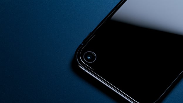 A black iphone sitting on a blue surface photo