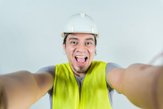 Funny builder engineer taking a selfie isolated, Engineer taking a selfie isolated. View of male engineer taking a selfie. Smiling male engineer taking a selfie looking at camera photo