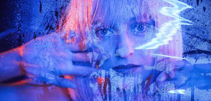 Looking at camera. Stylish woman with, white hair is behind wet transparent plastic sheet photo