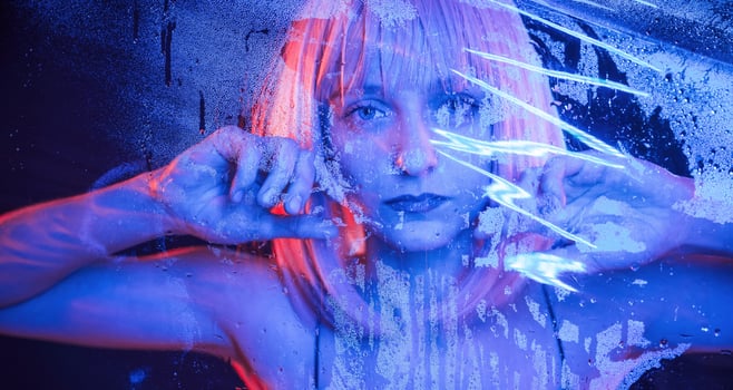 Futuristic ,style. Stylish woman with white hair is behind wet transparent plastic sheet photo