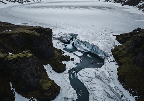 A river flows through a snowy mountain range photo