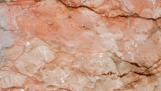 Textured layers of ochre and peach hues create a natural masterpiece on rocky terrain under soft sunlight photo