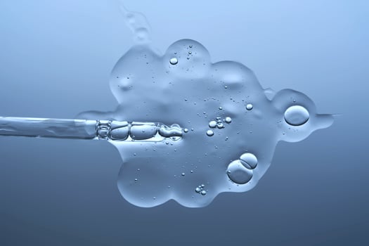 The texture of a serum with microneedles and a cosmetic pipette on a blue background. photo