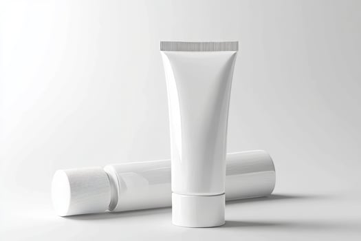 A tube of cream and a tube of toothpaste on a white background photo