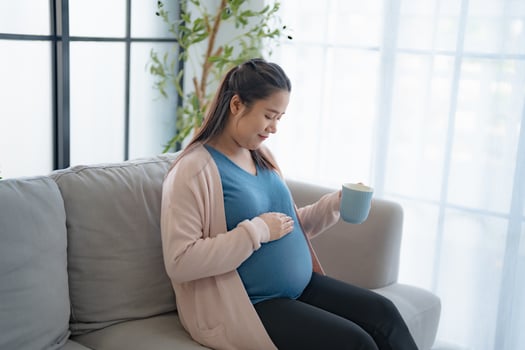 Pregnant asian woman drinking milk at home relaxation and Self-care drinking a glass of fresh milk mother mindfulness Positive life moment in pregnancy time photo