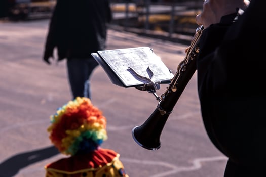 Clarinetist performing with colorful clown at outdoor event photo