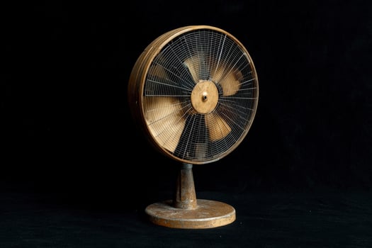 Vintage metal fan on a black background photo