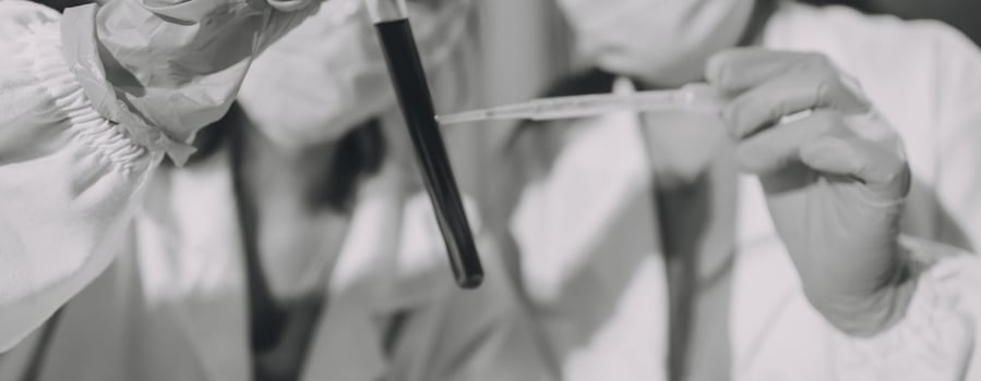 Two people in white lab coats holding a syringe photo