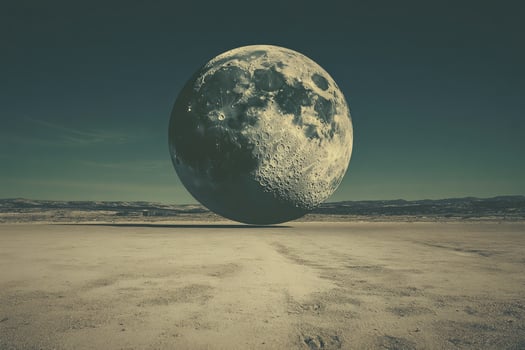 A large moon is shown in the desert photo