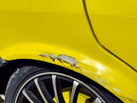Retro Car damage on a bright yellow vehicle with scratched paint and alloy wheels in sunlight photo
