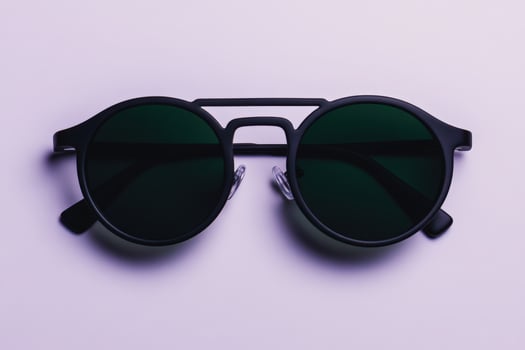 Modern black round sunglasses with tinted lenses displayed on a light background photo