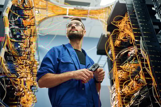 Cutting,, the wire. Young man is working with internet equipment in server room photo