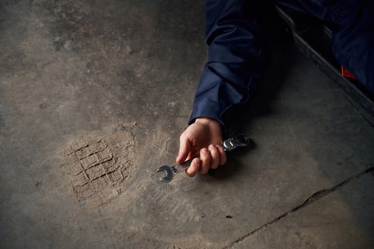 Repairman, is, lying down on the ground with tool in hand photo
