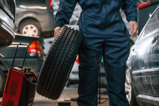 Holding, it in hand. Close up view of man that is moving tire of the car photo