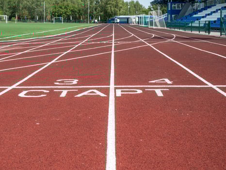 A Red treadmill at the stadium with white lines photo