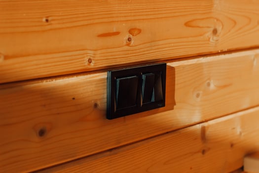 Elegant black switches contrast with warm wooden wall in cozy cabin setting photo