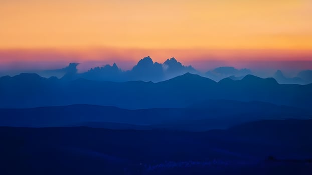 the sun sets over the mountains in this photo