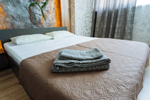 In a cozy bedroom space, there is a comfortable bed adorned with a warm brown blanket and crisp white sheets, creating a perfect atmosphere for restful nights and peaceful relaxation photo