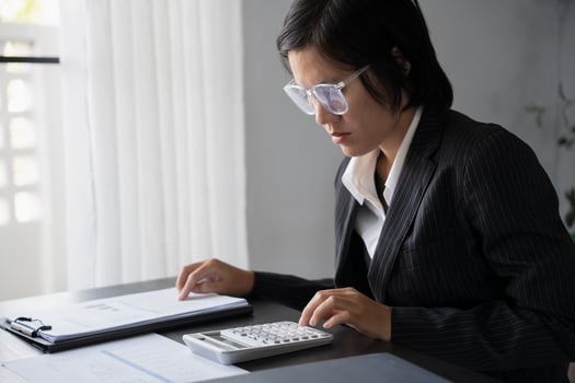 Middle age Asian woman Auditor or internal revenue service staff senior business woman checking annual financial elderly woman pressing calculator. photo
