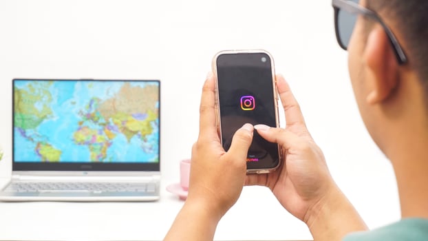 Yogyakarta, Indonesia, 2025 - Man holding smartphone showing Instagram application on the screen isolated on white background photo