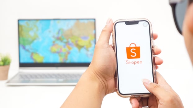 Yogyakarta, Indonesia, 2025 - Man holds smartphone with Shopee, electronic commerce or online shopping platform application is loaded on the screen isolated on white background photo