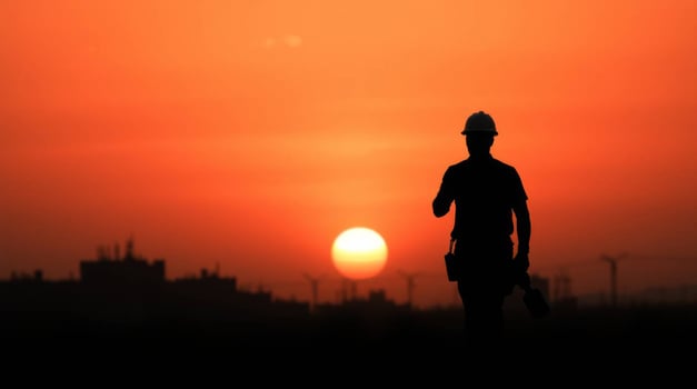 Silhouette of construction worker at sunset reflecting industrial progress photo