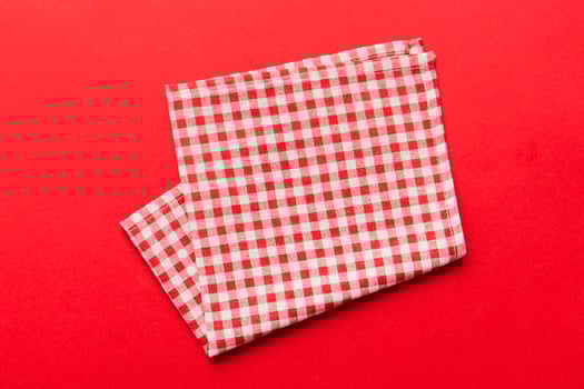 top view with red empty kitchen napkin isolated on table background. Folded cloth for mockup with copy space, Minimal style photo