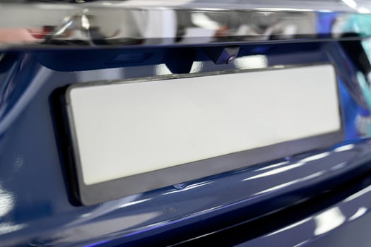 A close up of a blue car with a license plate photo