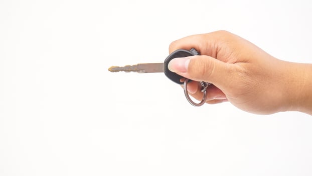 Hand holds motorbike or motorcycle key isolated on white background photo