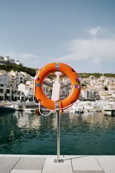 Lifebuoy on a stand with a latch stands on the shore of Lustica Bay. Montenegro photo