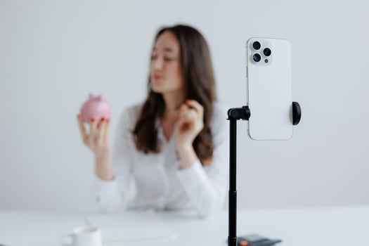Woman holding a piggy bank while recording a financial advice in a bright indoor space photo