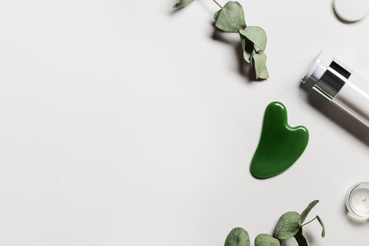 Gouache scrapes from green jade and moisturizing gel, floral decorated. Natural gem stones massager photo