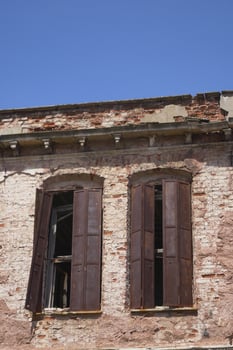 Old building with wooden shutters under clear blue sky photo