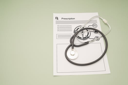Top view of a stethoscope over the medical prescription sheet on a green background. photo