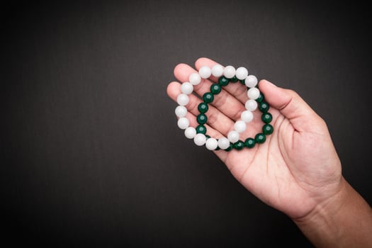 Jade bangles or bracelets in hand against a black background. Space for text. photo