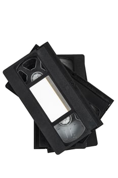 A set of old black VHS tapes stacked neatly, representing a bygone era of film technology. photo